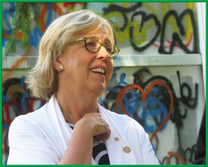Elizabeth May, in front of a wall of graffiti