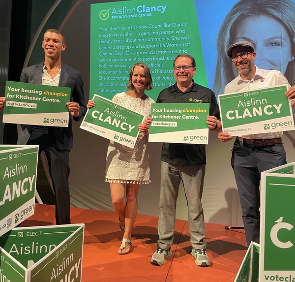 Jonathan Pedneault, Aislinn Clancy, Mike Schreiner, and Mike Morrice hold Green Party signs to elect Aislinn Clancy for Kitchener-Centre.